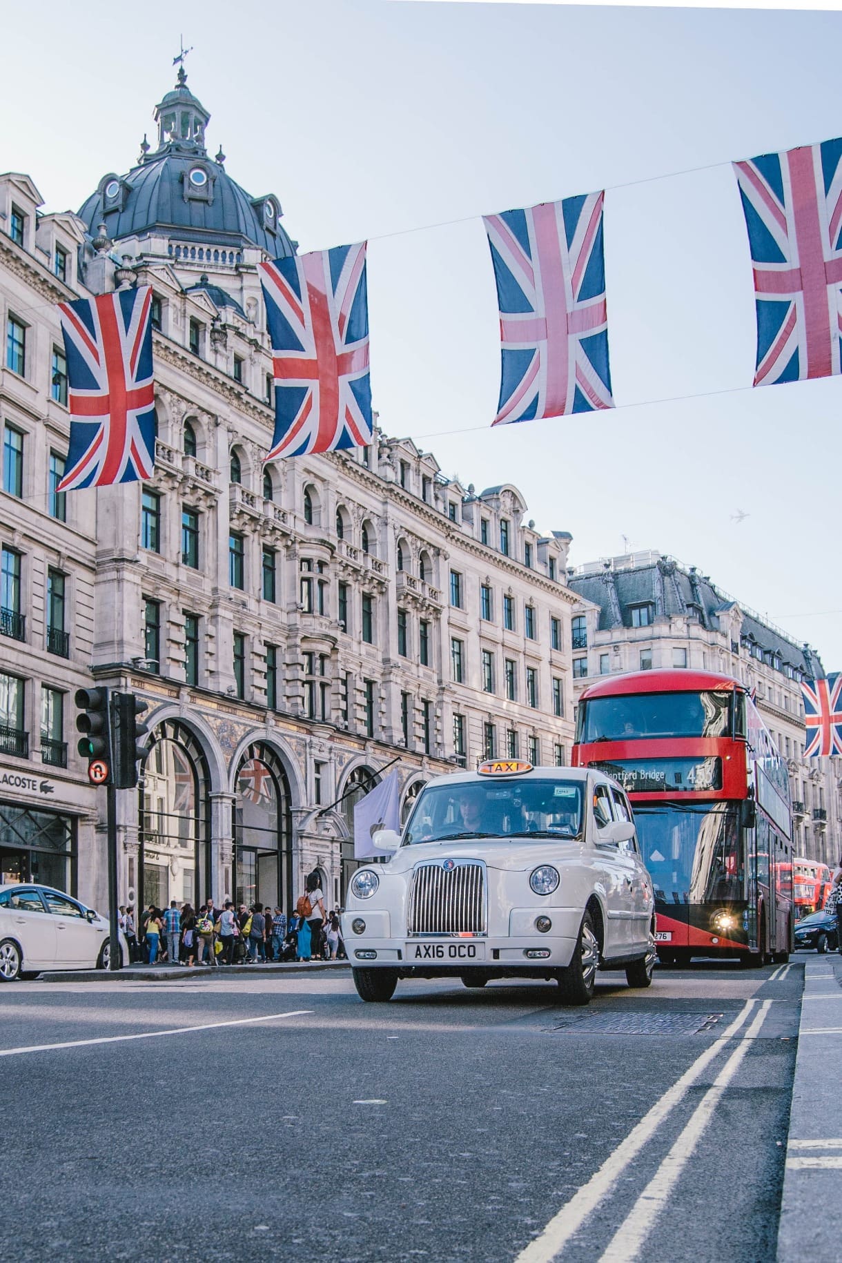 Picture of a street in London with a taxi and bus on the road and union jack bunting