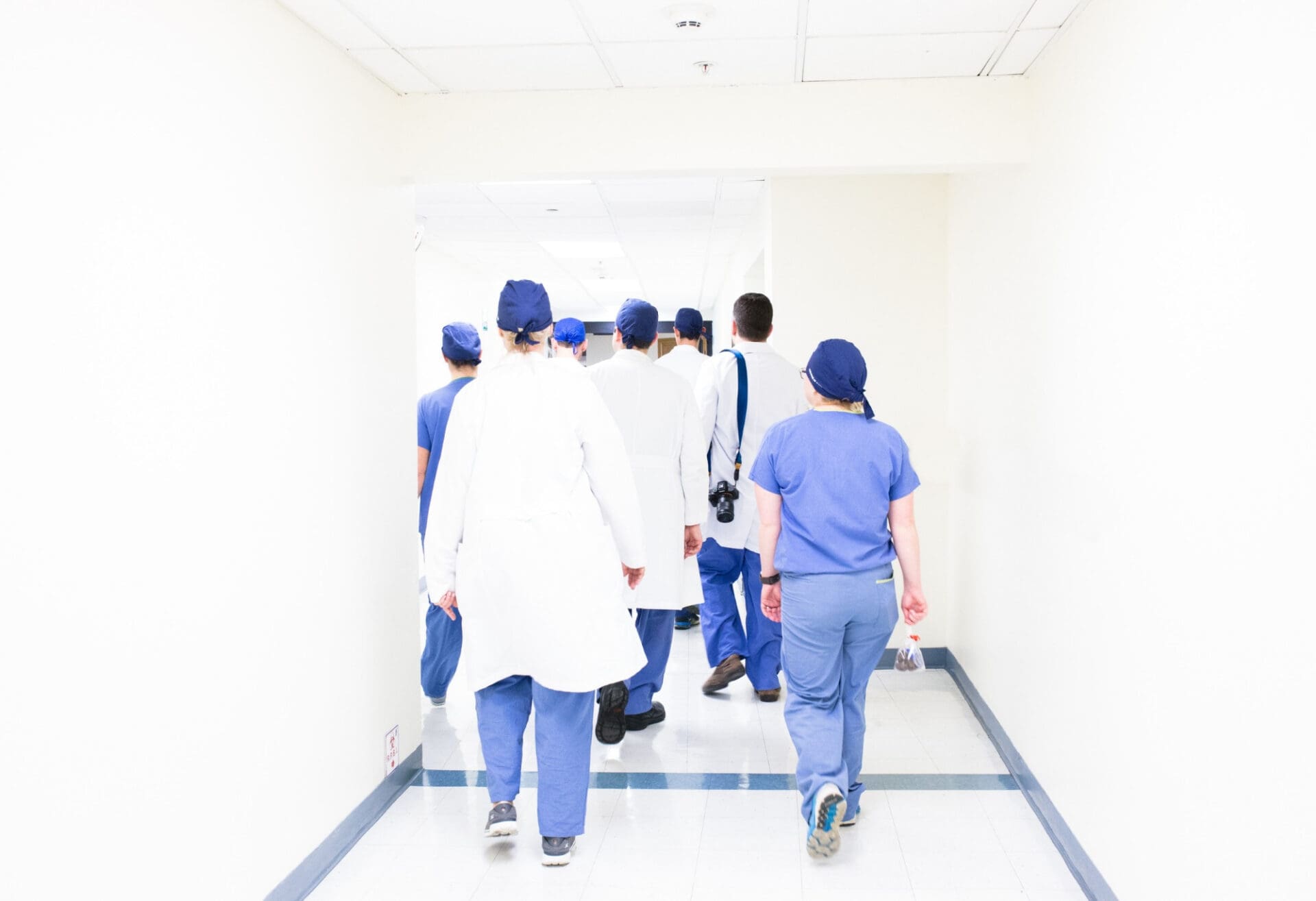 A group of doctors in scrubs walking down a hallway